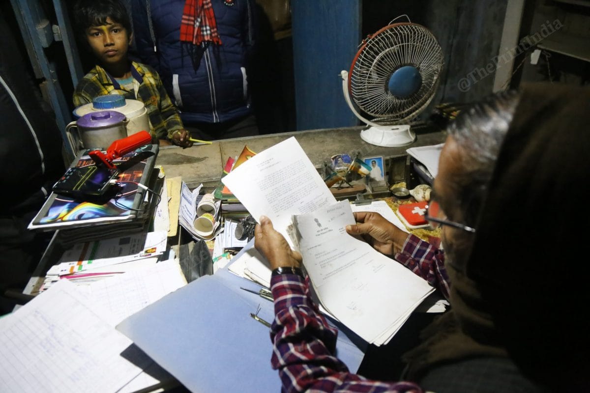 Prasad Mandal goes through his pile of documents. 