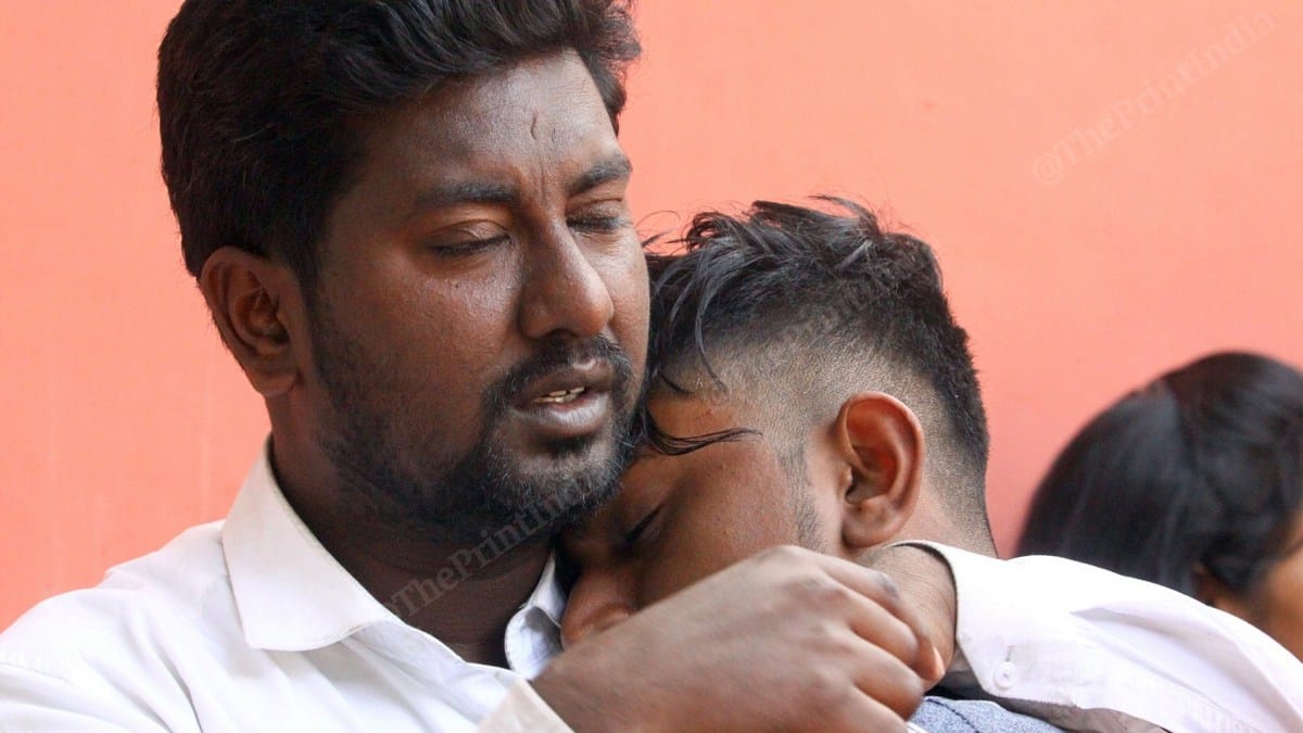 Shahbaz mourns his friend Rahul Solanki's death at GTB Hospital, while another friend consoles him | Photo: Praveen Jain | ThePrint