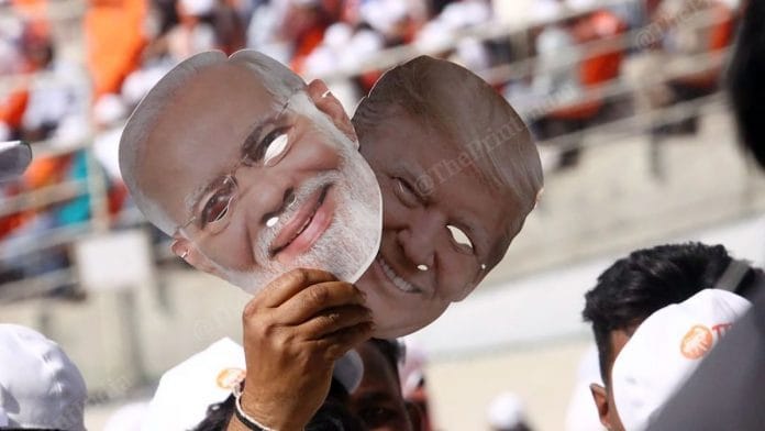 A man holding masks of Prime Minister Narendra Modi and US President Donald Trump at the Motera stadium in Ahmedabad. Photo: Praveen Jain/ThePrint