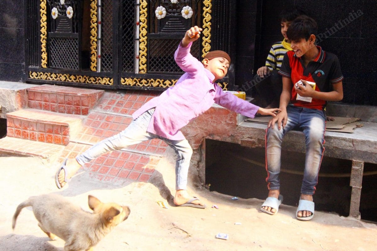 A boy playing with a dog in Mustafabad | Photo: Praveen Jain | ThePrint