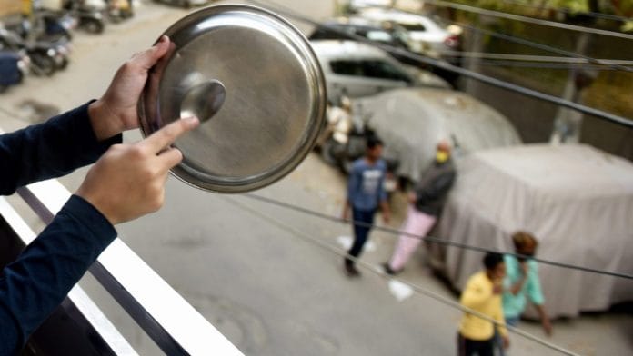 People clap and clang utensils for workers and medical practitioners fighting coronavirus during Janta curfew, in New Delhi | PTI