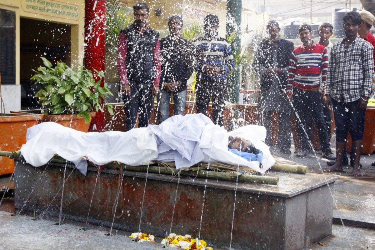 Before burning, the body is being washed with Ganga water | Photo: Praveen Jain | ThePrint