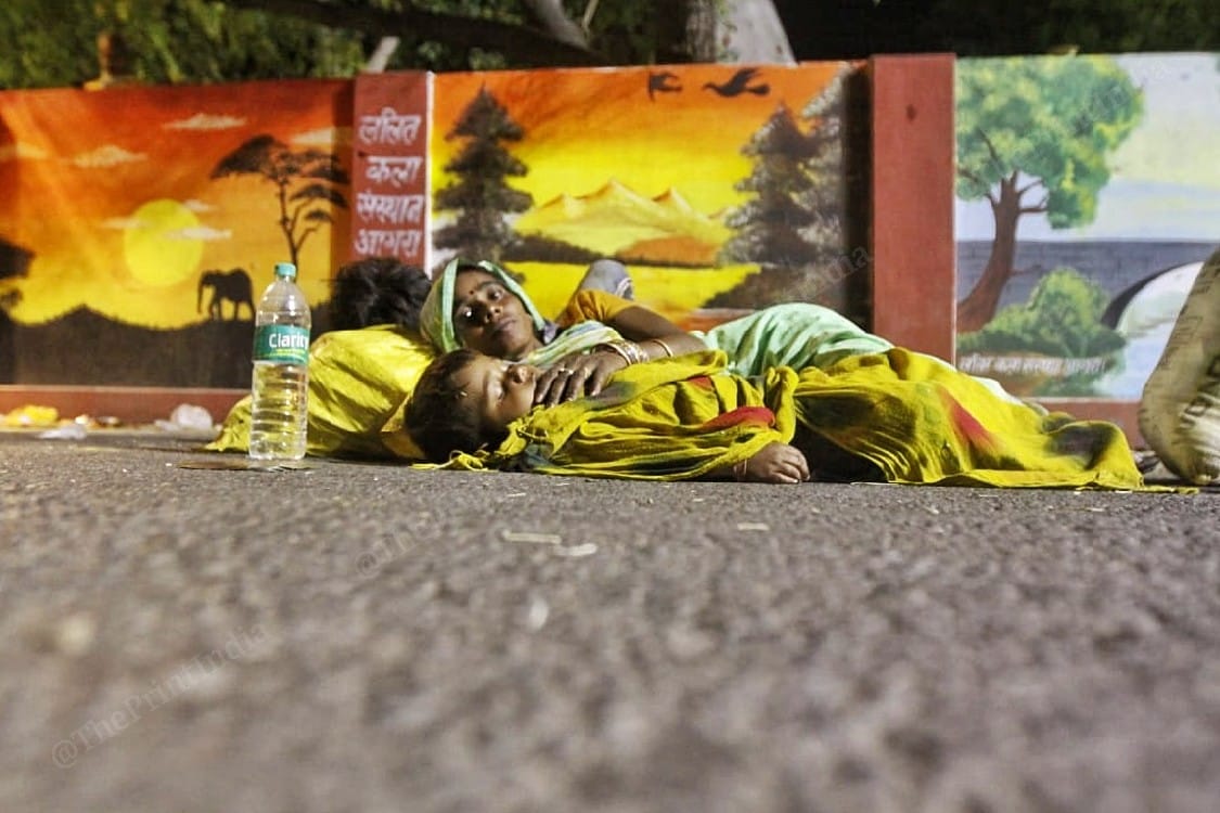 A woman sleeping with her child on the road | Photo: Praveen Jain | ThePrint