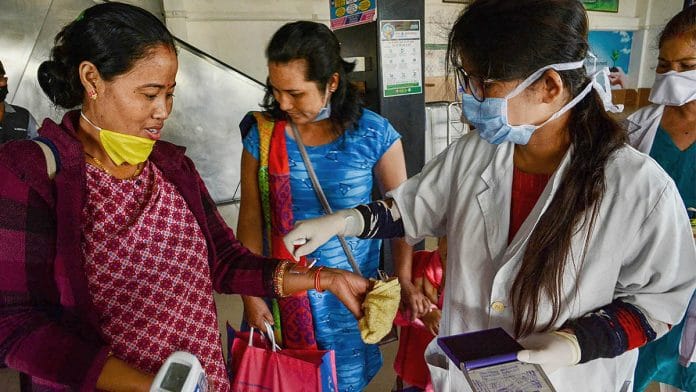 Medics place home quarantine stamps after thermal screening at Guwahati Railway station in wake of the coronavirus pandemic | PTI