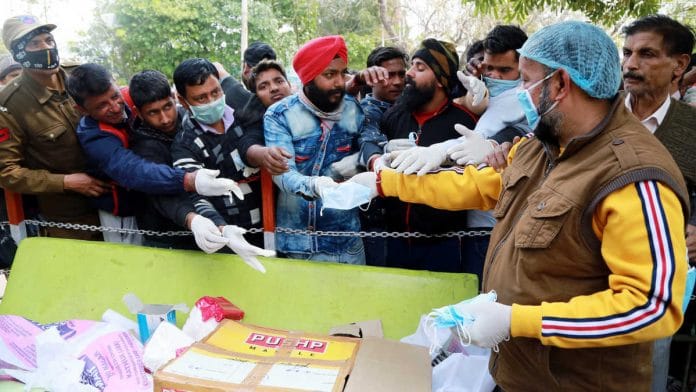 A volunteer distributes masks to people in Jammu to prevent the spread of coronavirus | Photo: ANI