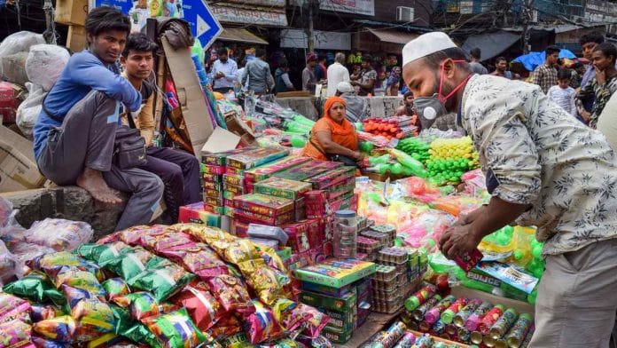 A hawker wears mask as prevention against coronavirus while selling Holi colours, at Chandni Chowk on 5 March
