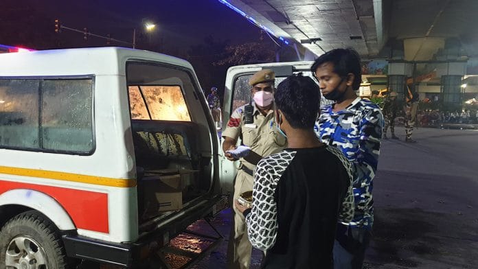 Delhi Police personnel distribute food at the IP Extension flyover | Photo: Y.P. Rajesh | ThePrint