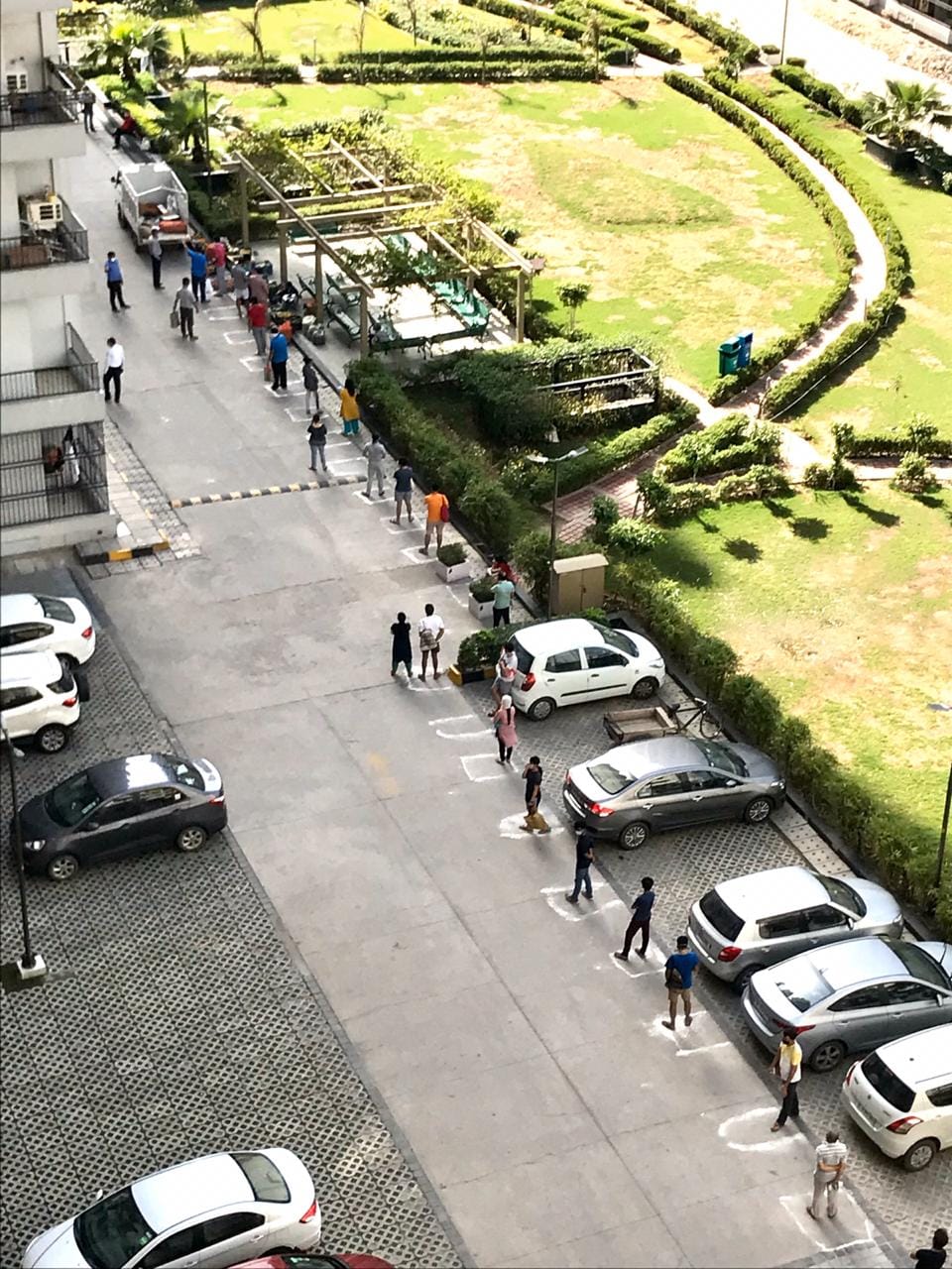 People wait for their turn to buy from a vegetable vendor inside a housing society in Noida | ThePrint