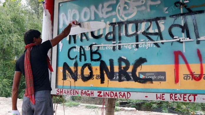 A man painting over protest graffiti at Shaheen Bagh in Delhi | Photo: Suraj Singh Bisht | ThePrint