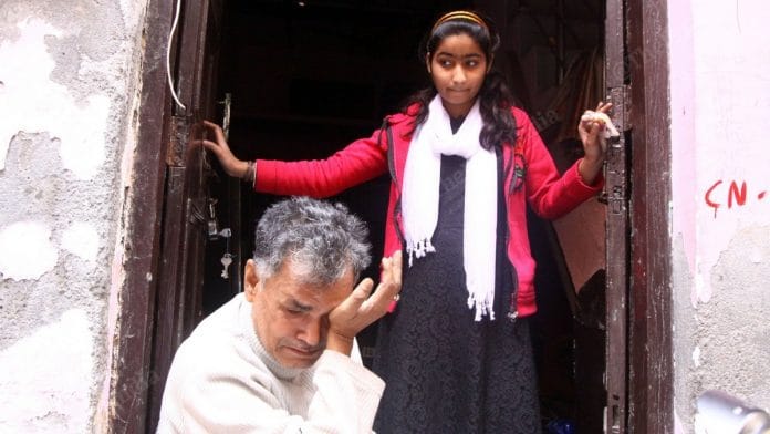 Asif Saikiya with his 14-year-old daughter Alvina, return to their ransacked home in Shiv Vihar. | Photo: Praveen Jain | ThePrint