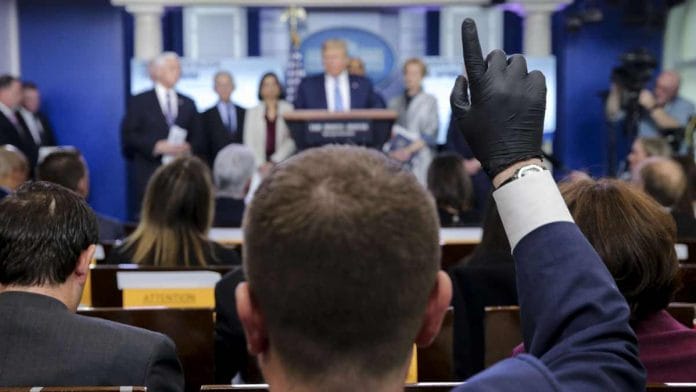 A member of the media wears protective gloves during a briefing by US president Donald Trump on the administration's response to coronavirus, on 16 March 2020 | Oliver Contreras | Sipa via Bloomberg
