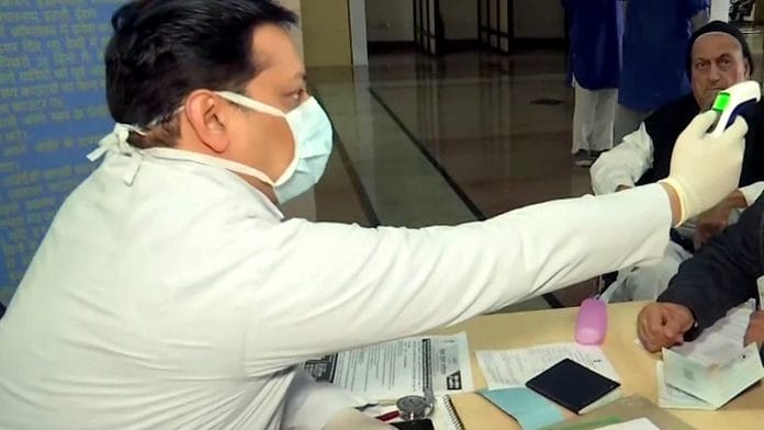 A doctor checks the body temperature of man through thermal screening at Wagah Attari Border amid the coronavirus outbreak, in Amritsar | ANI