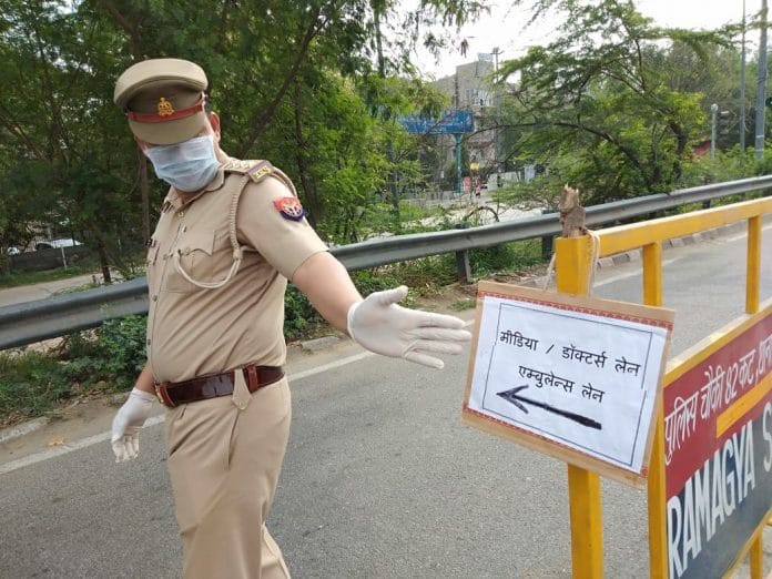 A policeman points to the separate lane for the media and doctors at the Noida-Delhi border Tuesday | Photo: Praveen Jain | ThePrint
