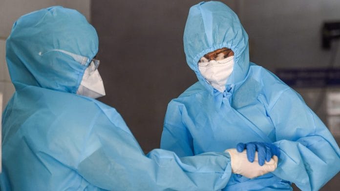 Doctors inside a protective chamber before collecting swab sample at a newly installed Walk-In Sample Kiosk (WISK) for COVID-19 test, in Chennai | PTI