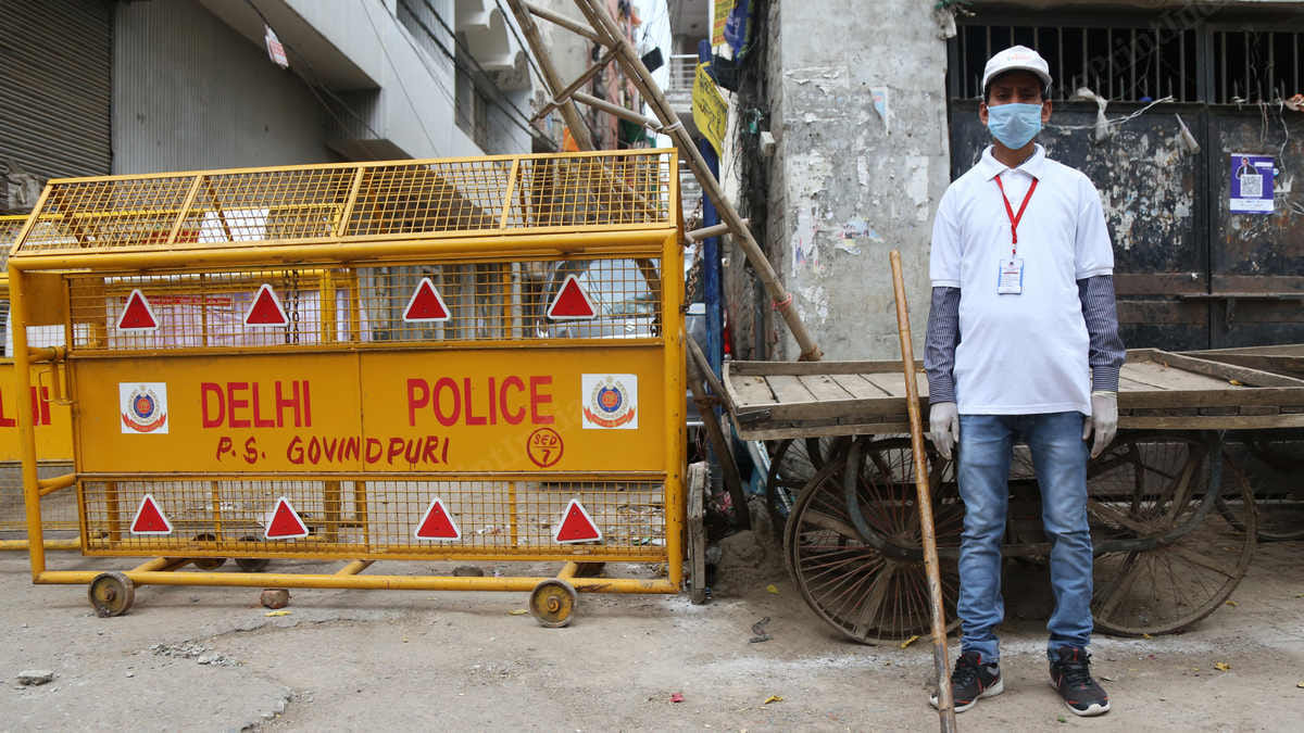 A local volunteer stands guard outside gali number 26 to enforce the complete lockdown | Photo: Manisha Mondal | ThePrint