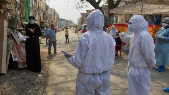 Members of a survey team in Indore trying to convince a family member of a Covid-19 patient to go to an isolation facility