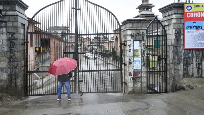 A man near the main gate of Jamia Masjid locked for the congregational Friday prayers in Srinagar on 27 March 2020