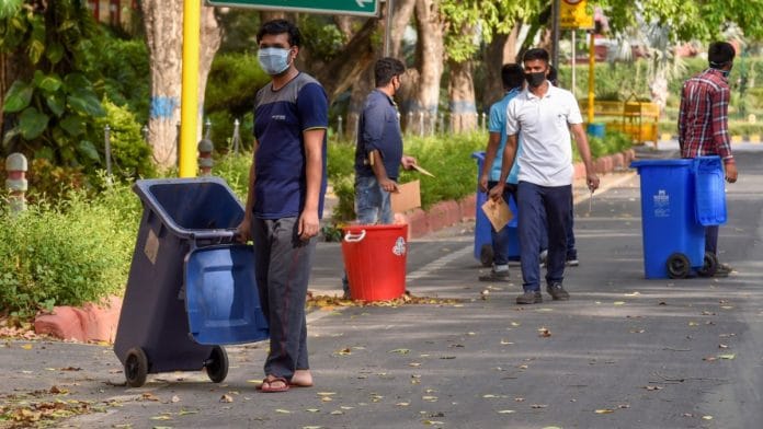 Workers clean a road in central Delhi, during a nationwide lockdown in the wake of coronavirus pandemic, in New Delhi | Atul Yadav | PTI