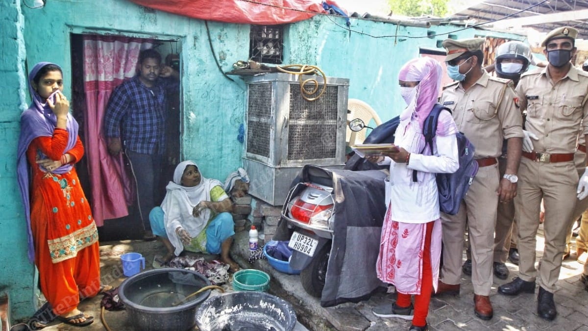 A medical worker speaks to a local as a part of the screening exercise for coronavirus cases in Sadar Bazar | Praveen Jain | ThePrint