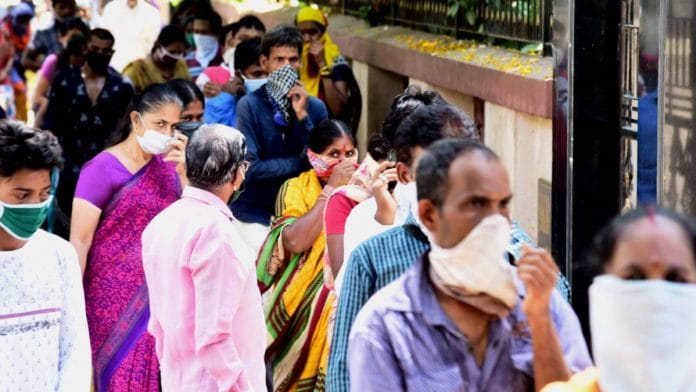 People stand in a queue at a food distribution point during the nationwide lockdown in Navi Mumbai on 24 April 2020 | PTI
