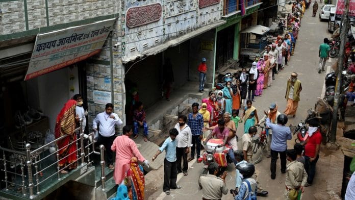People stand in a queue to take free essential commodities during the nationwide lockdown to curb the spread of coronavirus, in Prayagraj on 8 April | ANI