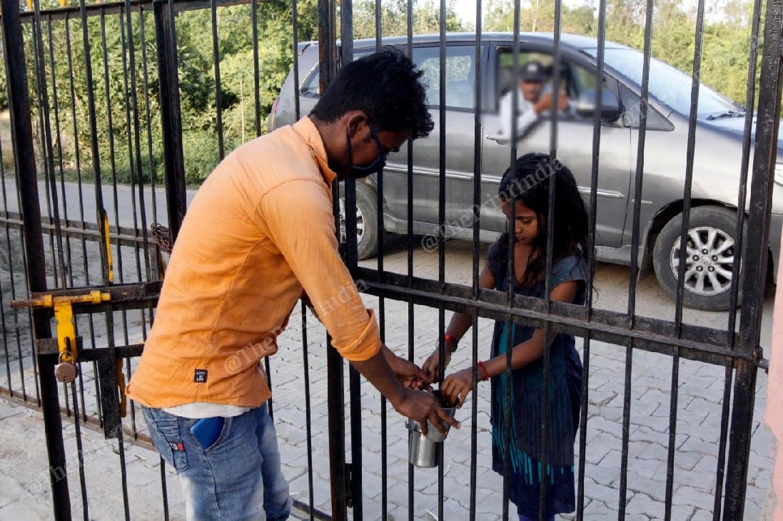 Sahibaan, 18, receiving tea from his 10-year-old sister Kismat | Photo: Praveen Jain | ThePrint