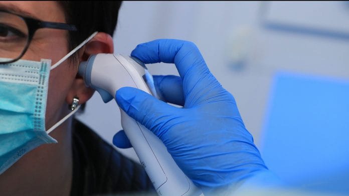 A doctor places a thermometer into a patient's ear during coronavirus symptom tests. (Representational Image) | Photographer: Krisztian Bocsi | Bloomberg