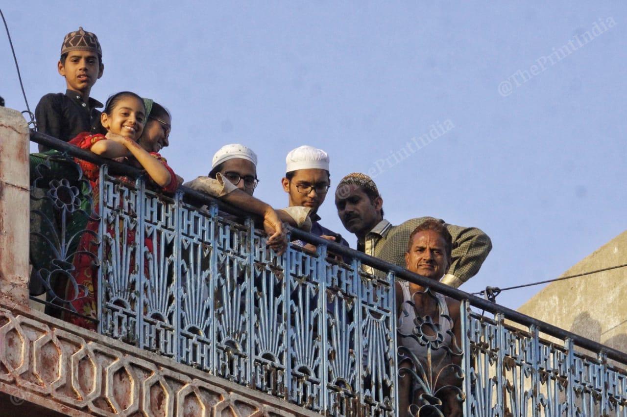 People peek out of their terraces to watch Covid-19 tests being administered on the street below in Jaipur's Ramganj. | Photo: Praveen Jain