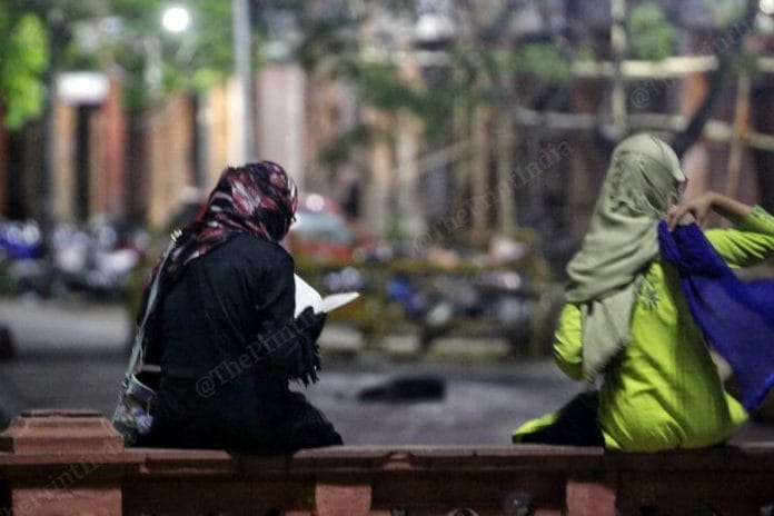 A woman reads the Quran before being ushered into an ambulance in Jaipur. | Photo: Praveen Jain/ThePrint