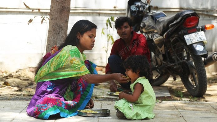 A mother feeding her daughter in a migrant shelter in Delhi | Photo: Manisha Mondal | ThePrint