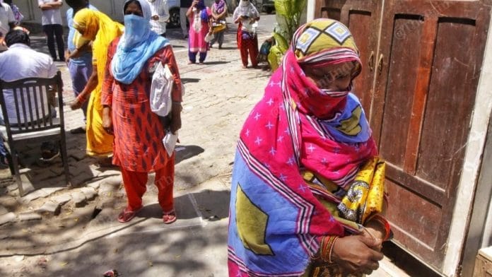 A woman stands in queue outside the Dalibagh ration shop in Lucknow. | Photo: Praveen Jain/ThePrint