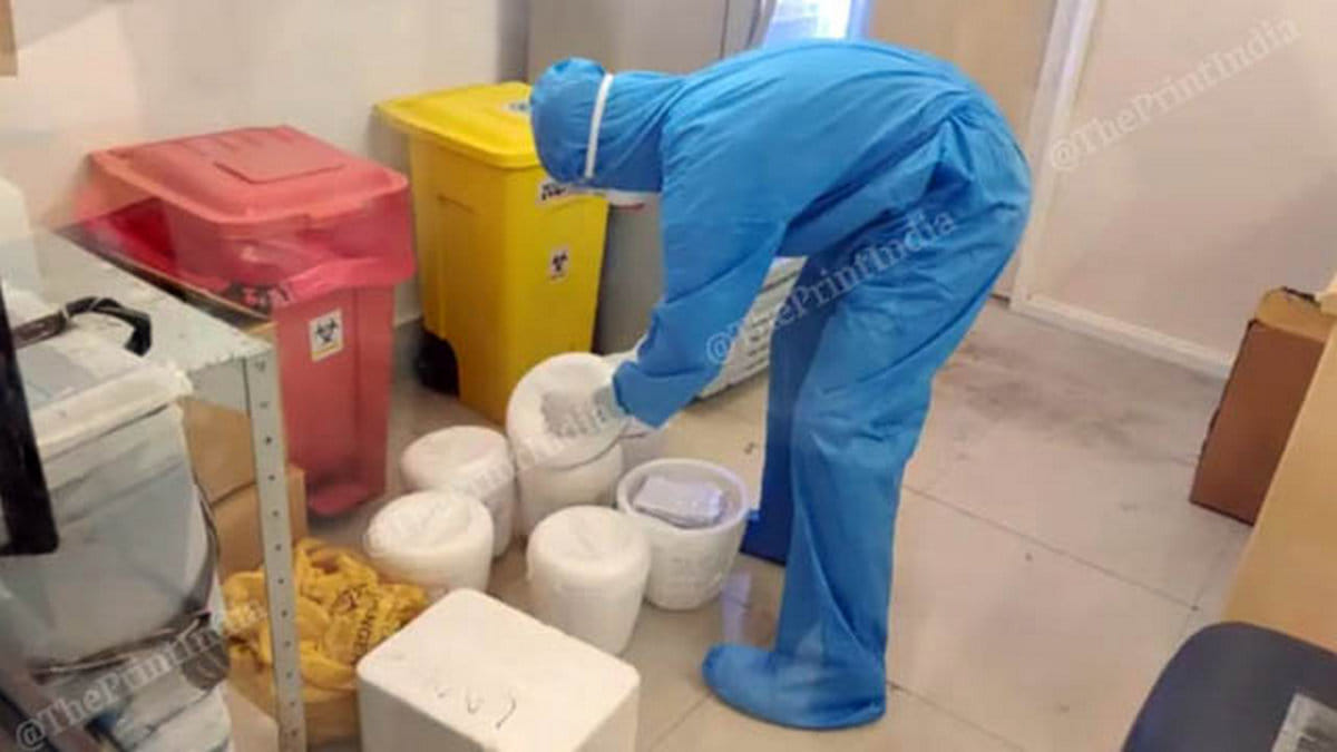 A technician handles thermocol boxes containing swab samples of suspected Covid-19 patients | Photo: Angana Chakrabarti | ThePrint