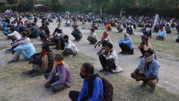 Homeless people and migrant workers sit in rows at the Yamuna bank in New Delhi. | Photo: Manisha Mondal/ThePrint