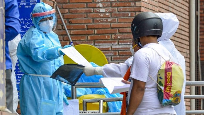 A medic checks the medical documents of a Covid-19 positive patient at a government hospital during the ongoing nationwide lockdown, in New Delhi, Monday, May 11, 2020. (PTI Photo/Kamal Kishore)