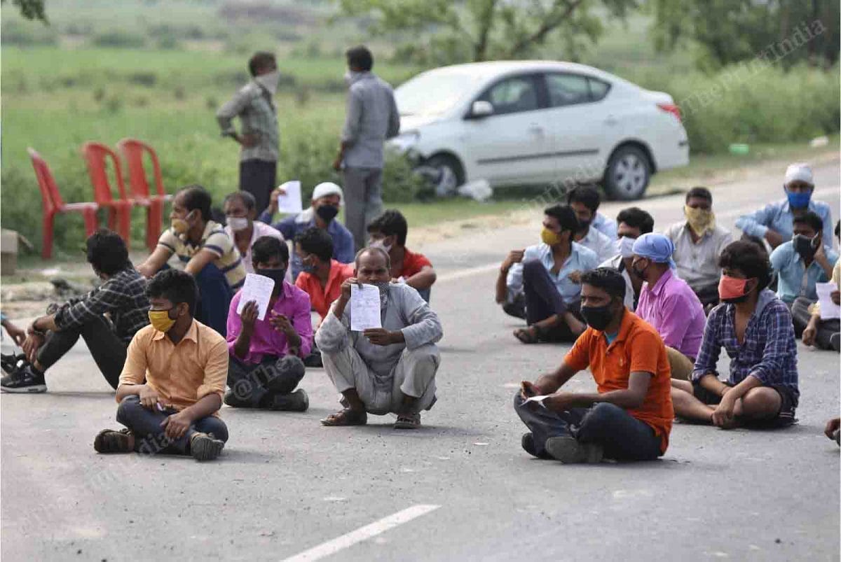 Migrant labourers have been on a quest to get back home. Here, they are seen sitting on the road near the Uttar Pradesh-Bihar border as they wait for their turn to be screened | Suraj Singh Bisht | ThePrint