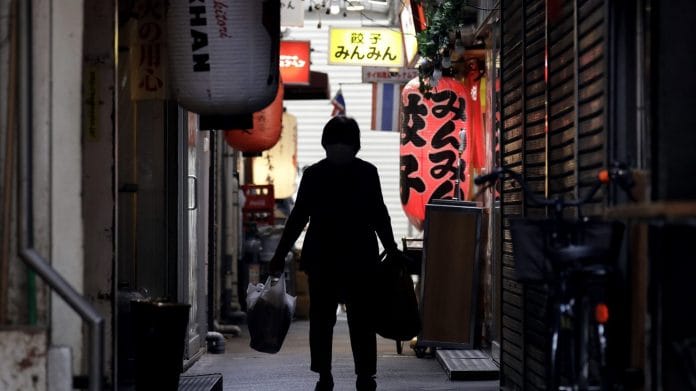 A shoper walks through an alley in the Kichijoji area of Tokyo on May 26. | Bloomberg