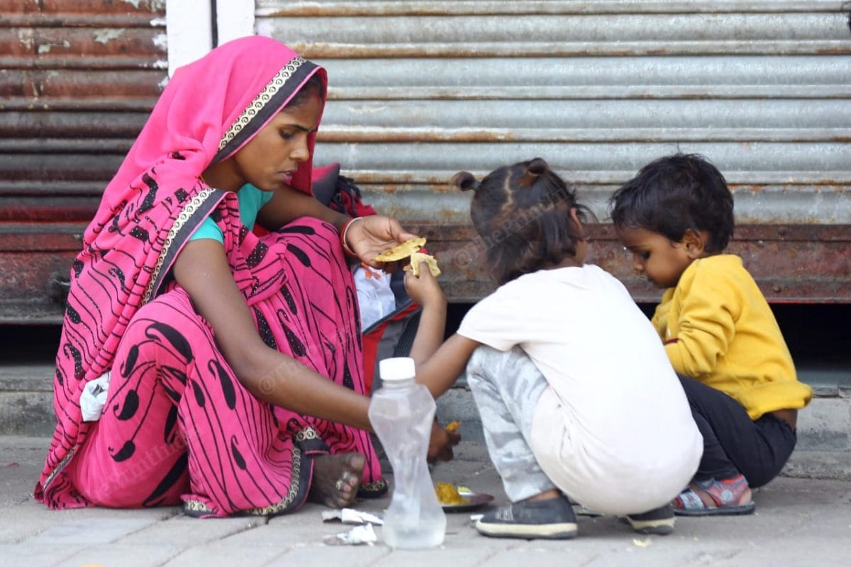 Mother serving her kids before getting into the train | Photo: Suraj Singh Bisht | ThePrint