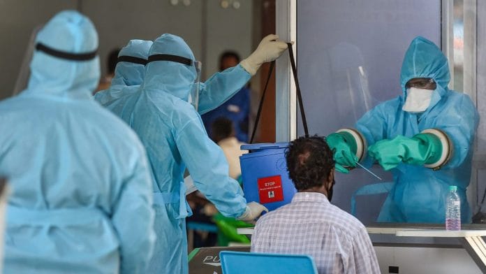 File photo of medic taking samples from an Indian national arriving from Myanmar at Anna International Airport, during the ongoing lockdown, in Chennai | PTI