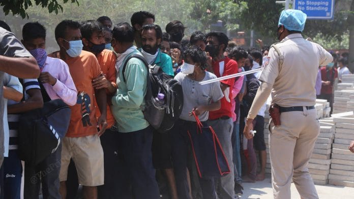 A policeman tries to control the crowd outside a liquor store in Shrinivaspuri, New Delhi | Photo: Manisha Mondal | ThePrint