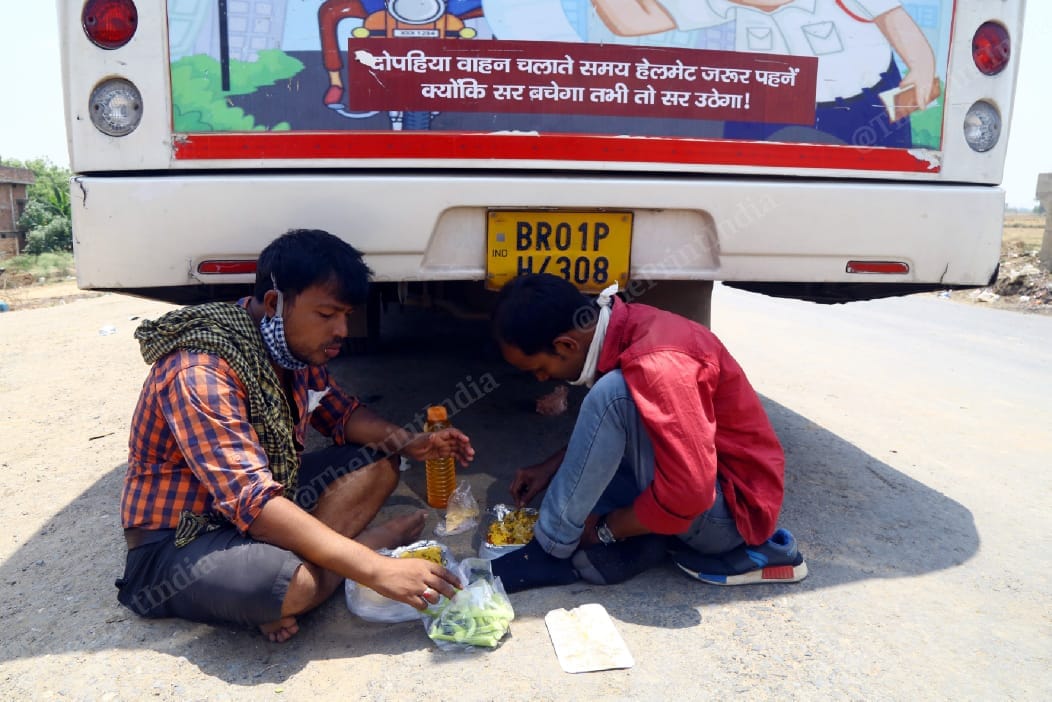 A group of migrants has a meal while waiting to catch the bus | Suraj Singh Bisht | ThePrint