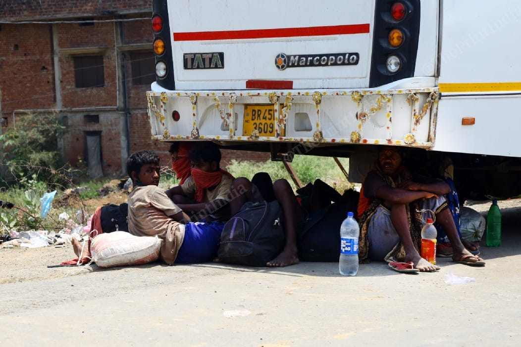 Migrants take a moment of rest under a bus | Suraj Singh Bisht | ThePrint