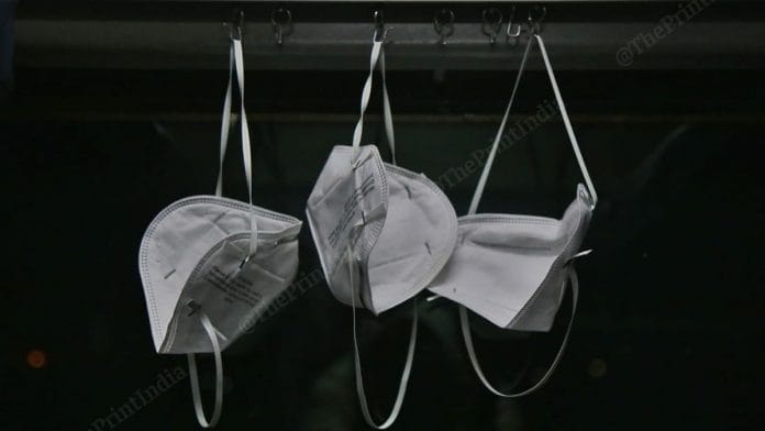 Three masks, belonging to three members of a family travelling to Vijaywada, hanging from hooks would hold curtains in the AC compartment | Manisha Mondal | ThePrint