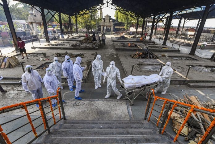 Representational image. Health workers and family members wearing protective suits perform the last rites of a person who died of Covid-19, during his cremation at New Delhi | PTI