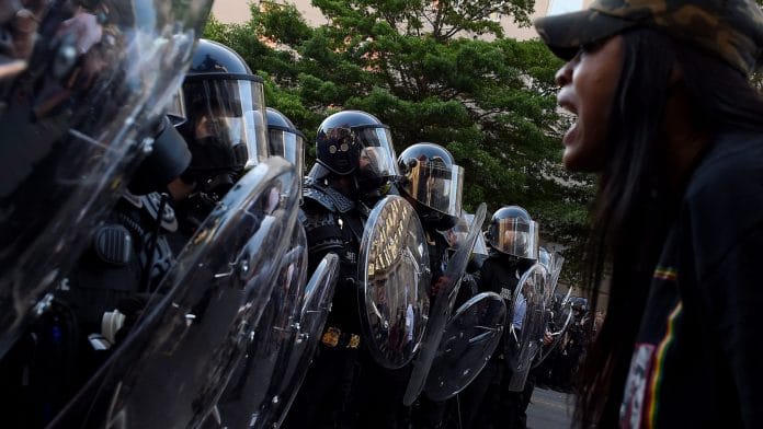 A protester screams in front of a row of police officers during a demonstration against the death of George Floyd at a park near the White House on 1 June, 2020 in Washington, DC. | Photographer: Olivier Douliery/AFP via Getty Images | Bloomberg