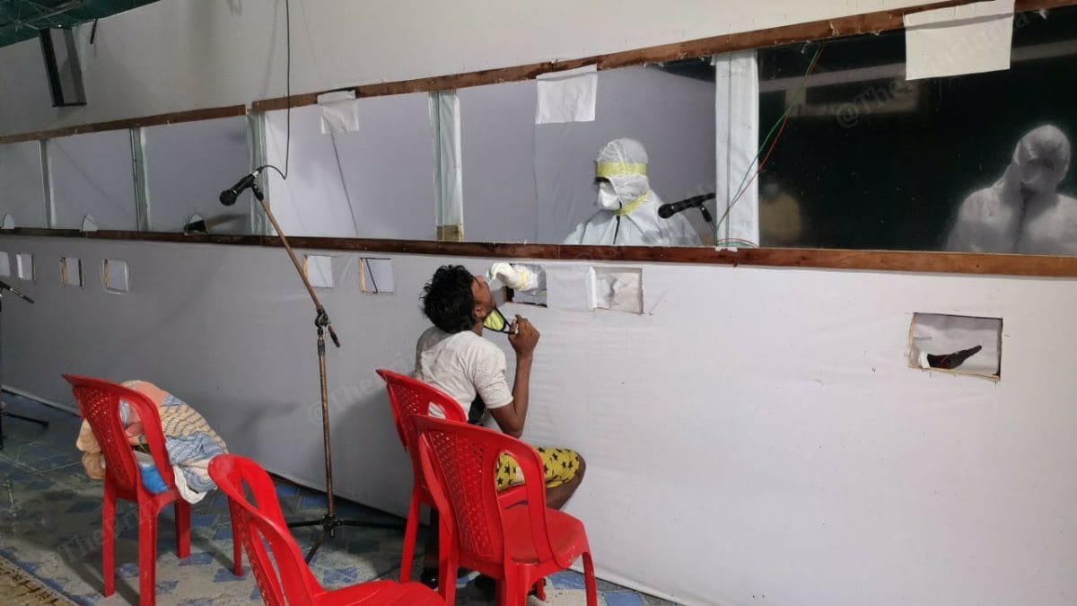 Health workers taking swab tests from one of the migrant labourers at a swab collection facility near the Assam-West Bengal border. | Photo: Angana Chakrabarti | ThePrint