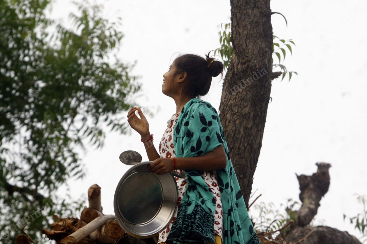 A girl in Baghai village looks up at the sky in shock and amazement at the swarm of locusts flying overhead. The swarm came in such large numbers that it darkened the sky | Praveen Jain | ThePrint