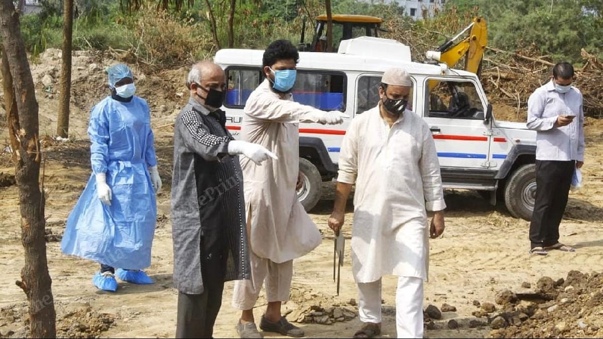Kalamuddin points out the grave of the man he had buried Saturday to his brother, Aninuddin, at Jadid Kabristan | Photo: Praveen Jain | ThePrint