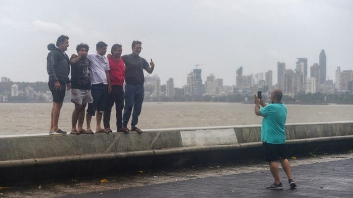 A group of people pose for pictures at Marine drive during Cyclone Nisarga, in Mumbai on 3 June 2020 | Shashank Parade | PTI