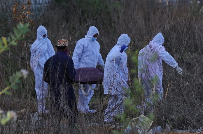 Workers carry a body at the Faqeer Mullah Kabristan in Balapur | By special arrangement