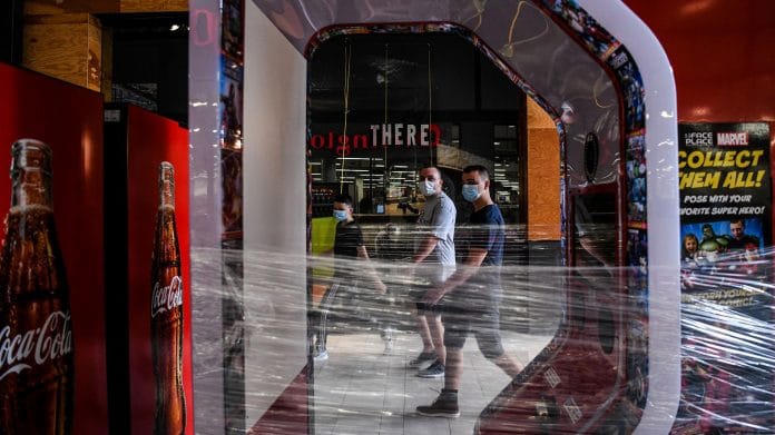 People wear masks as they walk inside a mall west in Florida.